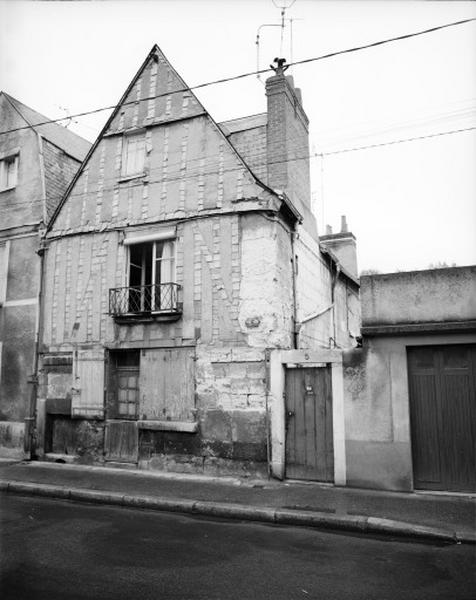 Façade antérieure sur rue : rez-de-chaussée avec boutique en pierre soulignée par un bandeau plat.