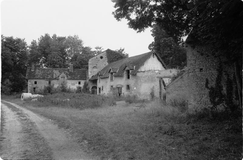 Vue d'ensemble de la ferme et du moulin à l'arrière-plan.