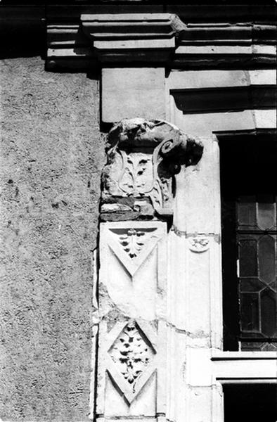 Façade ouest sur cour, partie sud, fenêtre de droite du deuxième niveau, détail du pilastre gauche surmonté d'un chapiteau.