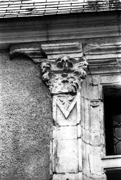 Façade nord sur cour, aile sud, fenêtre de droite du deuxième niveau, détail du pilastre gauche surmonté d'un chapiteau.