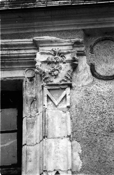 Façade nord sur cour, aile sud, fenêtre de gauche du deuxième niveau, détail du pilastre droit surmonté d'un chapiteau.