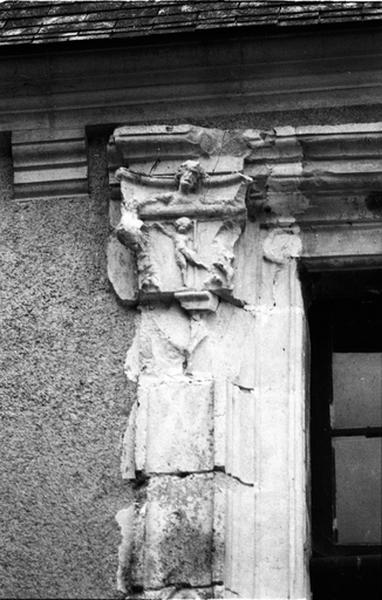 Façade nord sur cour, aile sud, fenêtre de gauche du deuxième niveau, détail du pilastre gauche surmonté d'un chapiteau.