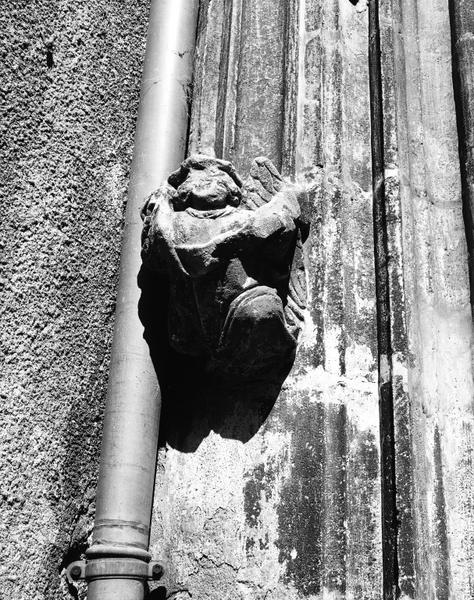 Façade sur cour, fenêtre du rez-de-chaussée : culot à personnage (gauche).