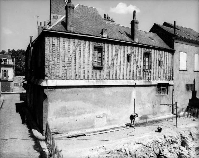 Façade antérieure sur la rue, vue de volume : pan de bois recouvert d 'ardoises et hourdis de briques en demi-épis enduit, en retrait par rapport au rez-de-chaussée. A noter, les écharpes en pan de bois.