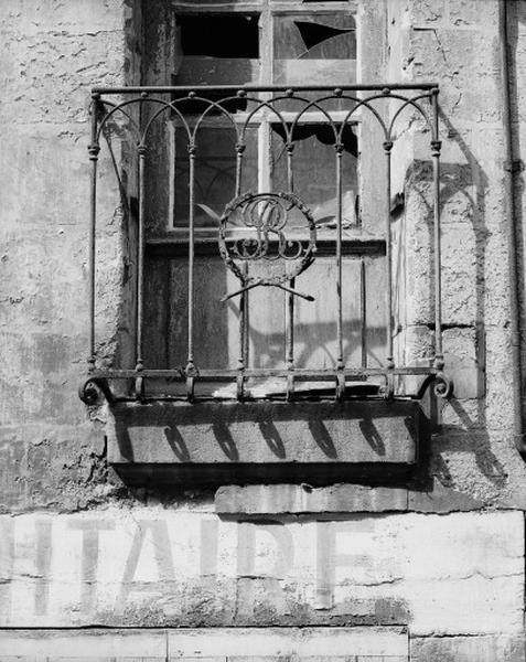 Façade antérieure sur rue, premier étage, grille de balcon en fer forgé avec une couronne de lauriers autour des initiales RB.