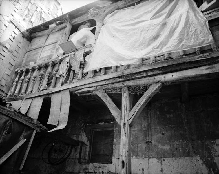 Cour, côté sud : galerie en bois avec garde-fou à balustres.