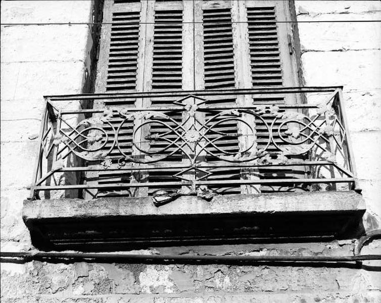 Façade antérieure sur rue, détail : grille de balcon en fonte, avec décorations végétales rapportées.