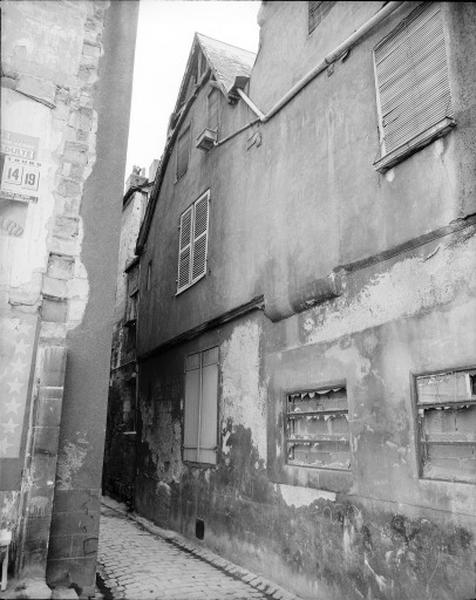 Façade antérieure sur rue avant démolition : construction en pan de bois sur rez-de-chaussée en pierre XVe-XVIe siècle. Celle de gauche porte une sablière d'étage moulurée terminée par un motif végétal en mauvais état.