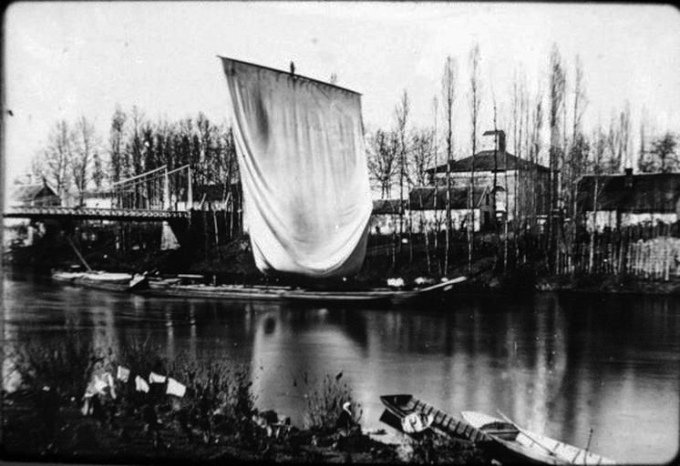 Bateau à voile passant sous le pont.
