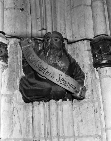 Transept sud, chapelle ouest, culot figuré représentant un personnage portant un phylactère avec un texte d'Isaïe : Saint, Saint, Saint EST LE Seigneur.