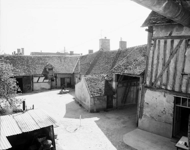 Vue d'ensemble de la cour prise de la galerie. Au fond, anciennes écuries-étables ; à droite, deux habitations.