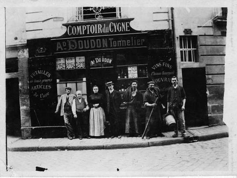 La façade principale et le personnel : boutique 'Comptoir du Cygne', 'Ad Doudon tonnelier, futailles en tout genre, articles de caves'.