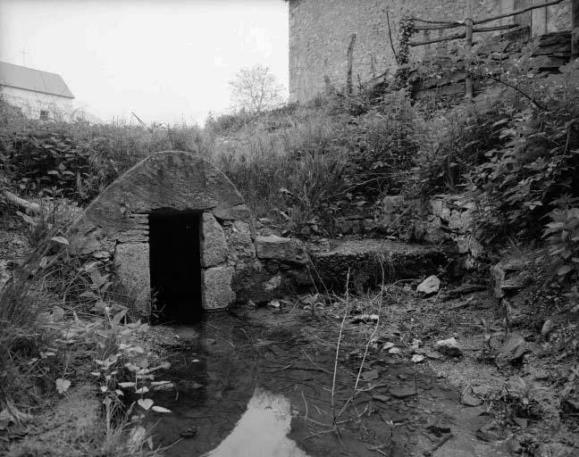 Fontaine Saint-Antoine située de l'autre côté de la route en contrebas de la chapelle que l'on aperçoit au fond à gauche.