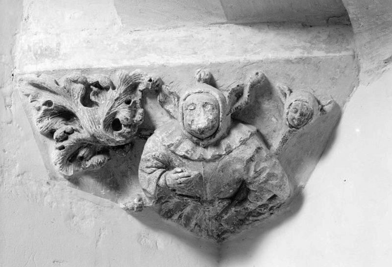 Escalier, intérieur. Détail : culot figuré, buste, homme et visage aux oreilles pointues et décor végétal.