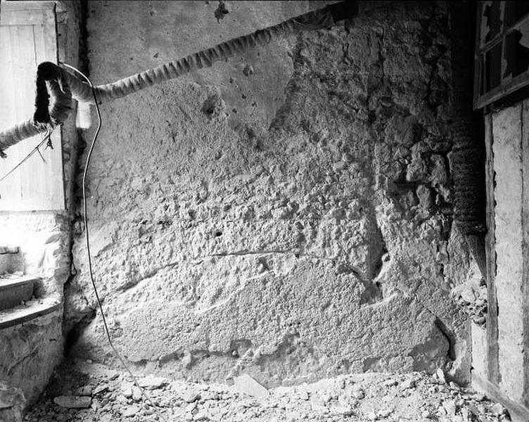 Logis ouest, rez-de-chaussée, salle nord, mur mitoyen avec la galerie, trace d'un arc de couvrement d'une porte.