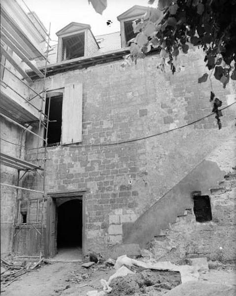 Corps de logis est, façade nord, détail. Le mur de petits moellons enduits a été prolongé et surhaussé au XIIIe siècle (?) par un mur d'appareil aux angles arrondis.