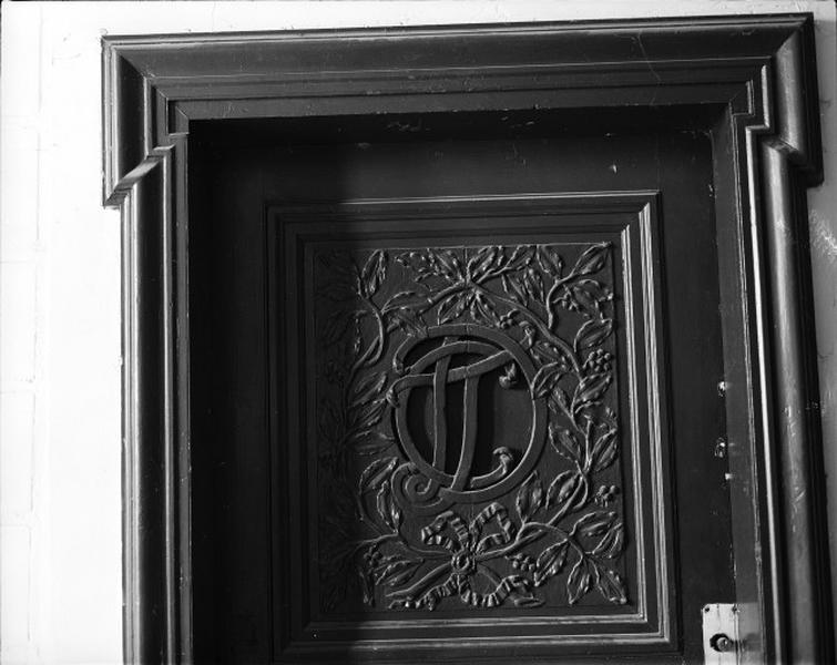 Porte palière premier étage : décor d'un arbre entouré de branchages en relief.