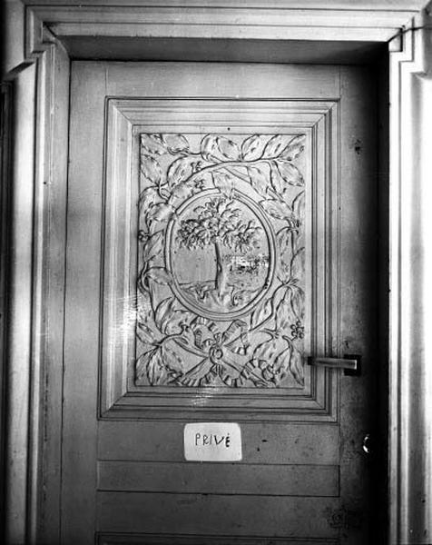 Porte palière premier étage, revers : monogramme entouré de branchages.