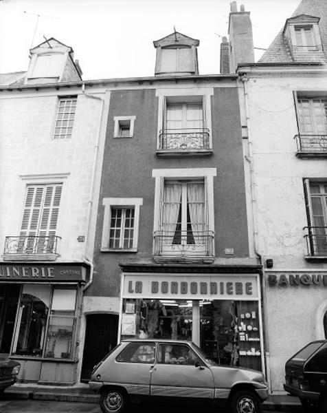 Façade antérieure sur la place très remaniée : balcon en pierre et grille de balcon XVIIIe siècle sur une maison antérieure (identique au n°51).