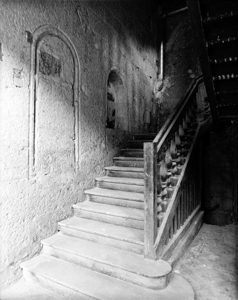 Aile est, escalier intérieur en bois, rez-de-chaussée : noter les baies murées sur le mur nord.