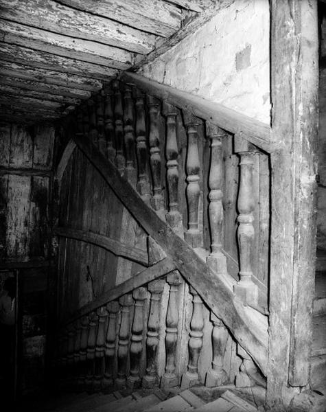 Escalier monumental rampe sur rampe, à balustres en bois.