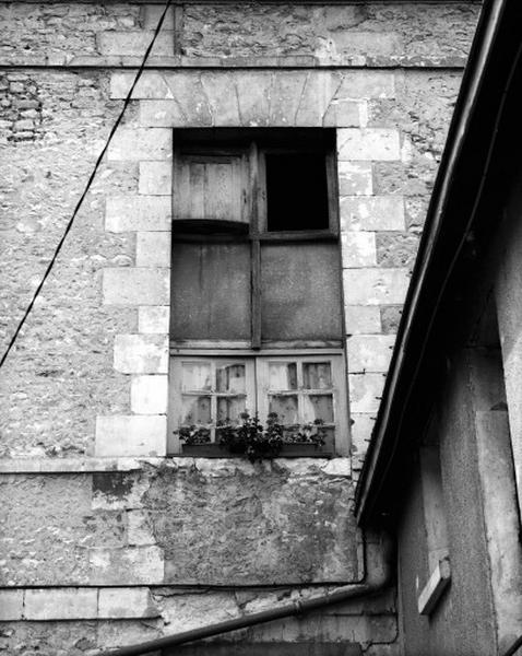 Façade sur cour, premier étage, deuxième travée à droite : vestige de la croisée en bois.