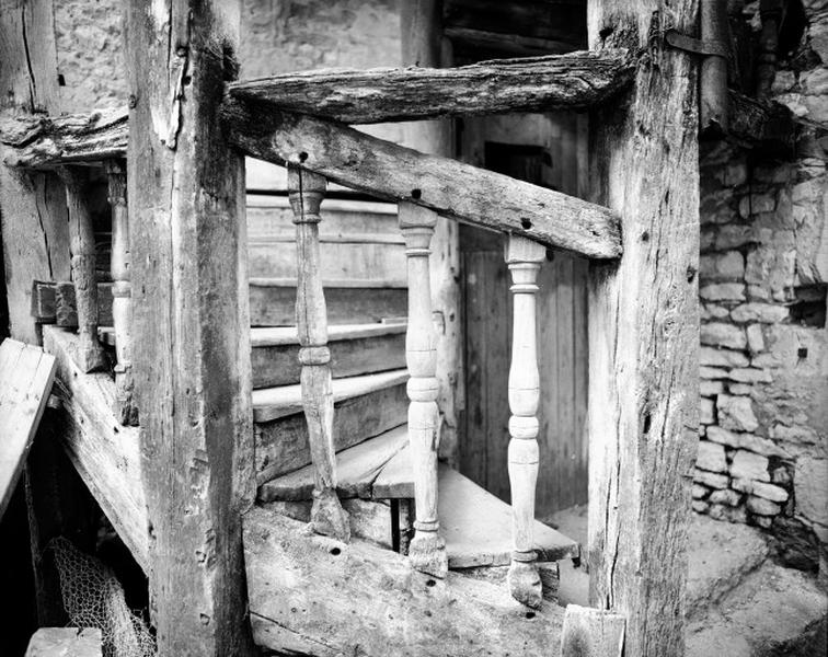 Cour : escalier en vis en bois, détail : balustres symétriques.