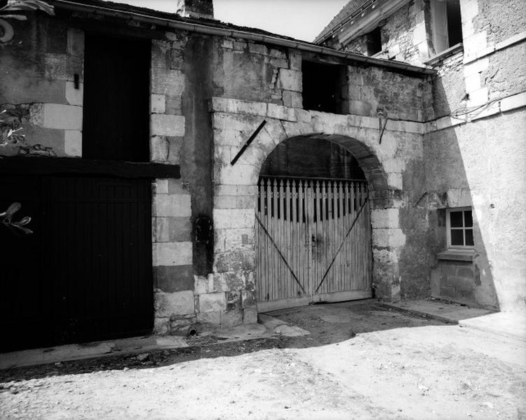 Bâtiment fermant la cour à l'ouest : portail dans la cour recouvert d'un arc en anse-de-panier.