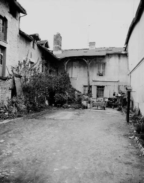 maison d'habitation en fond de cour (ouest) : escalier de distribution extérieur en pierre recouvert d'une charpente.