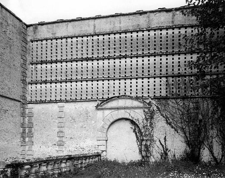 Vue de détail de l'angle du mur-pigeonnier et de l'une des portes murées débouchant primitivement dans la cour des communs, de l'ouest.