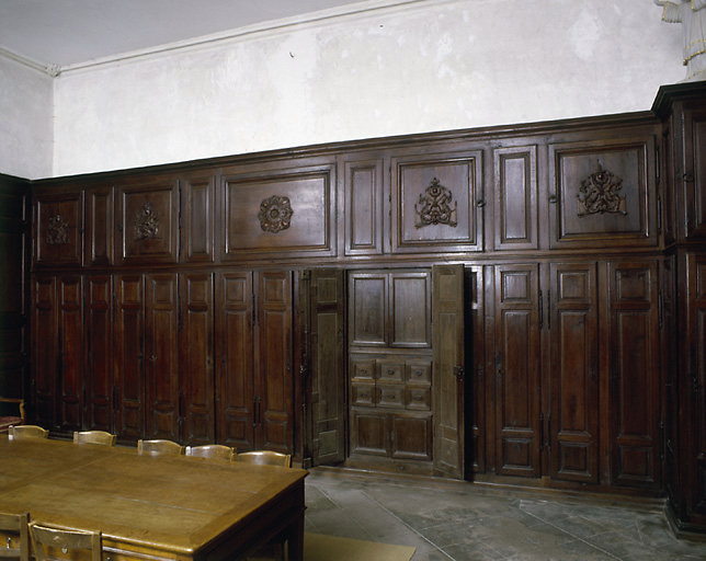 Vue d'ensemble, côté ouest : série de portes longues et étroites enfermant des vestiaires, un lavabo, d'autres palcards plus petits. Au dessus placards de rangements plus larges.