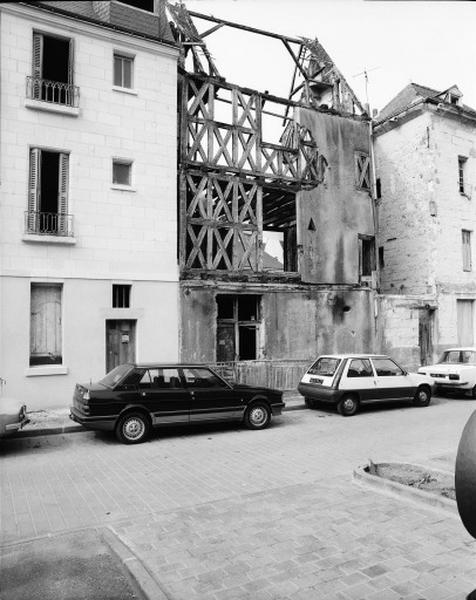 Maison en pan de bois, façade antérieure en cours de démolition : la croisée du rez-de-chaussée est mise au jour, la mise en oeuvre du pan de bois est en croix de saint André, le rez-de-chaussée est en pierre.