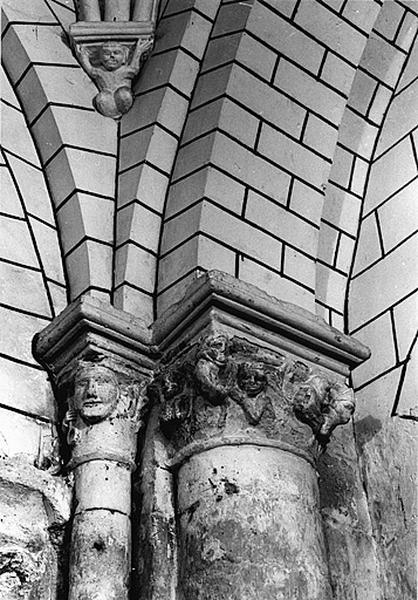 Vue de détail du pilier sud-est du carré du transept : chapiteau à personnages et chapiteau sculpté de la tête de saint Pierre.