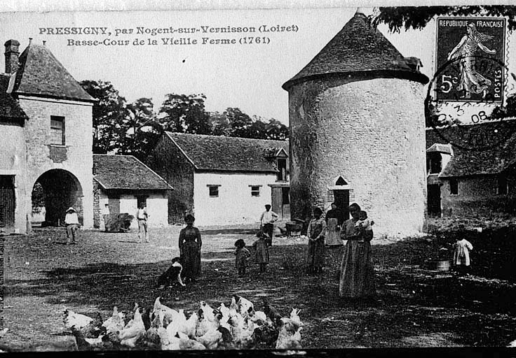 Vue intérieure de la cour du château avec le pigeonnier au premier plan vers 1900 (carte postale ancienne).