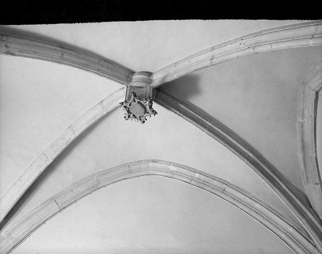 Eglise, fonts-baptismaux, détail de la voûte (emblème des Augustins à la clef).