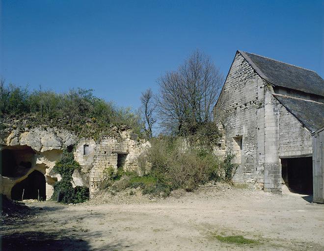 A gauche, dépendances semi troglodytiques et en partie ruinées. A droite, face occidentale de la chapelle.