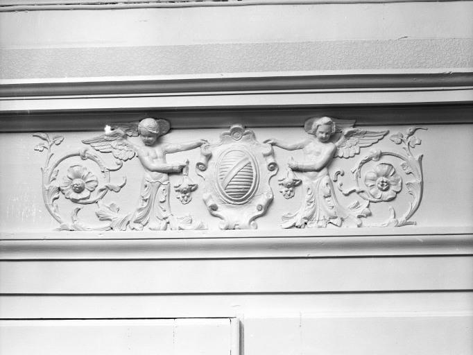 Villa Saint-Lazare. Hall de l'escalier, détail dessus de porte (droit). Rinceau à putti ailés tenant l'écu aux armes de J.S. Chambert-Pean.