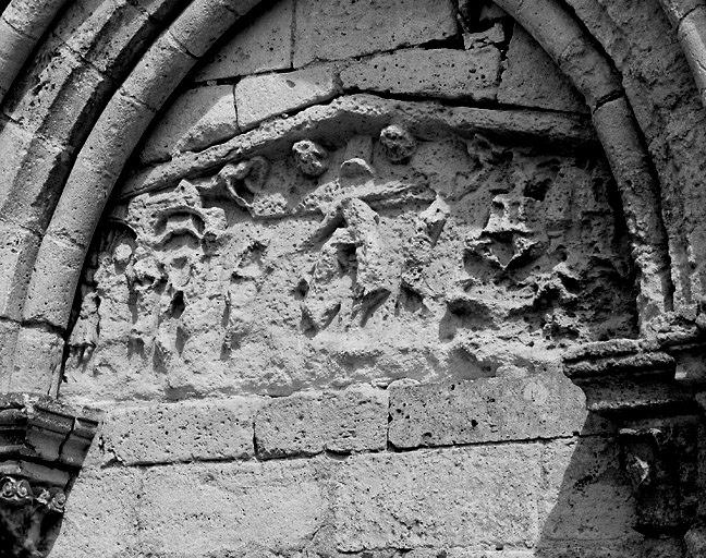 Eglise, façade ouest, linteau en bâtière remployé dans l'arcade aveugle de gauche : Jugement du Christ chez Pilate, Descente de croix et Mise au tombeau.