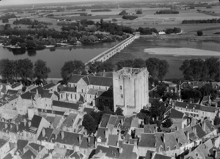 Vue aérienne prise en 1968 avec au premier plan les maisons implantées sur les anciens fossés du château. On aperçoit ensuite le donjon, le logis seigneurial et l'abbatiale.