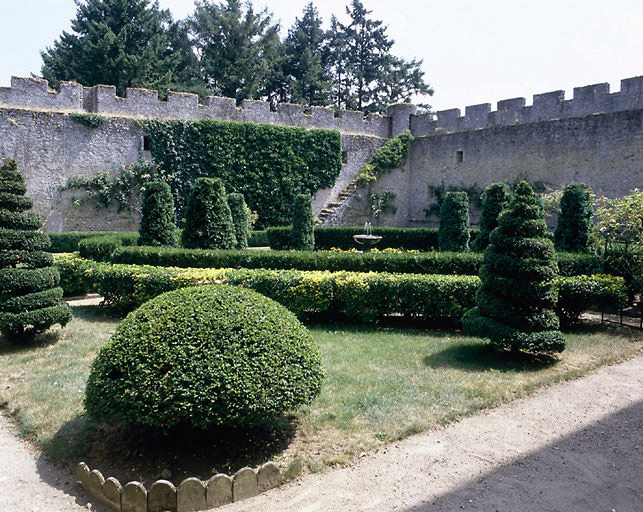 Le jardin compartimenté et enfermé de murs crénelés.