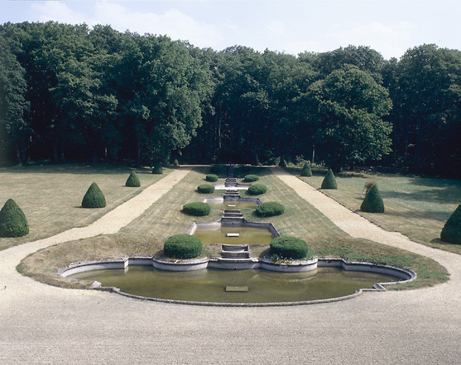 L'escalier d'eau vu depuis la grande salle du 1er étage : des ifs taillés ponctuent chaque gradin. L'eau semble venir du parc. Au fond la composition s'achève dans un hémicycle de rododhendrons.