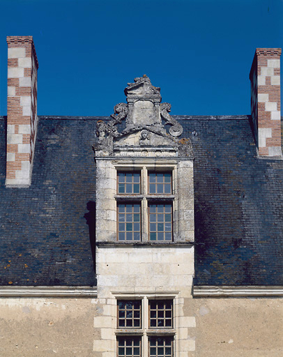 Logis principal, façade sur la cour, détail : lucarne centrale à gauche. Le fronton est orné d'une tête de femme.