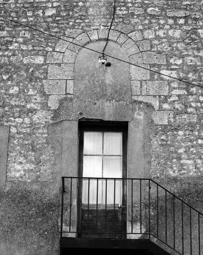 Vestige de baie romane sur le pignon ouest du bâtiment à usage de salle des malades et chapelle.