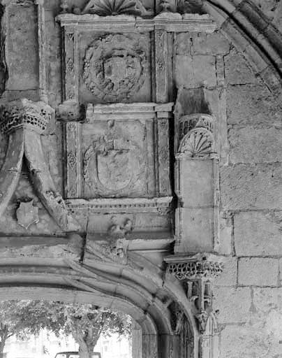 Détail de la partie supérieure de l'ancien portail d'entrée de l'église sous le porche : armoiries des Orléans-Longueville entourées de l'ordre de Saint-Michel dans le médaillon supérieur.