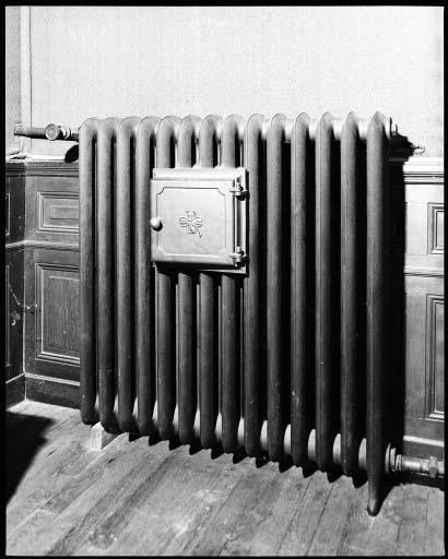 Un radiateur de chauffage central avec chauffe-plat fermé dans la salle a manger.