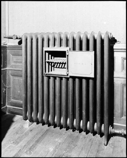 Un radiateur de chauffage central avec chauffe-plat ouvert dans la salle a manger.