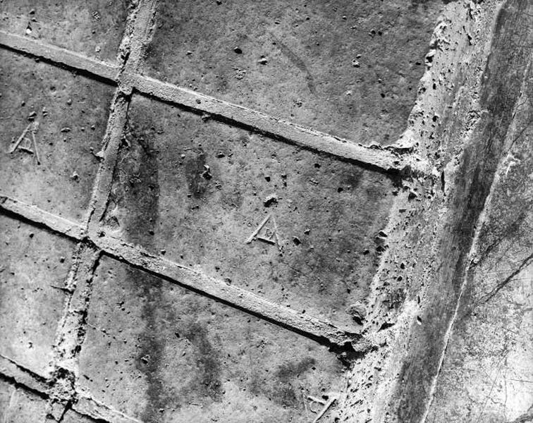 Détail de la cheminée de l'ancien salon : briques portant les initiales A. et D.