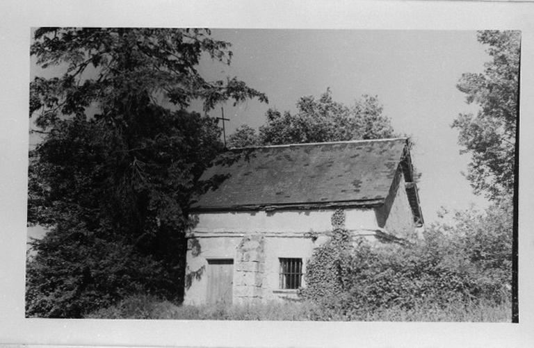 La chapelle entourée de végétation.