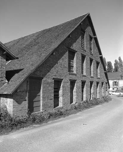 Halle de séchage percée de baies fermées de persiennes à lames orientables permettant la ventilation (mur pignon nord).