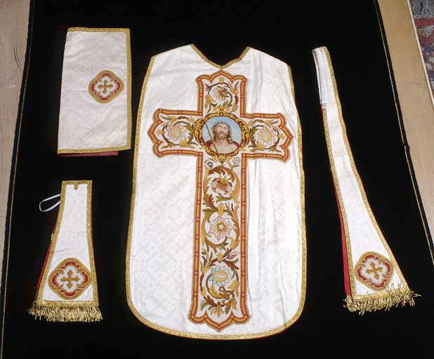 Ensemble avec chasuble vue de dos : croix et tête du Christ au centre.